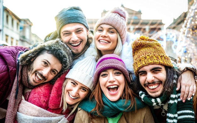 Des amis à la mode, des gars et des filles prenant un drôle de selfie sur des vêtements de mode chauds