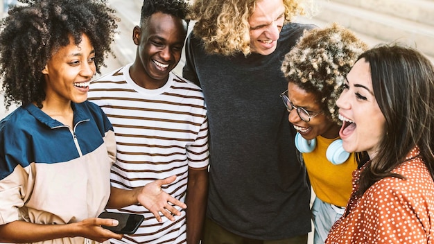 Amis multiraciaux s'amusant à rire ensemble à l'extérieur