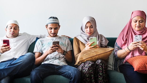 Photo amis musulmans utilisant les médias sociaux sur les téléphones