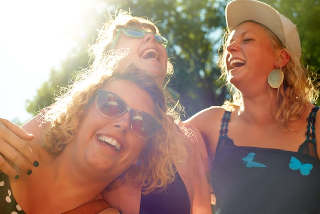 Photo les amis de la nature et les femmes au soleil rient pendant les vacances et les week-ends à l'extérieur le sourire heureux et le visage des gens s'embrassent pour se lier, s'amuser et se détendre ensemble lors de voyages d'aventure et de voyages.