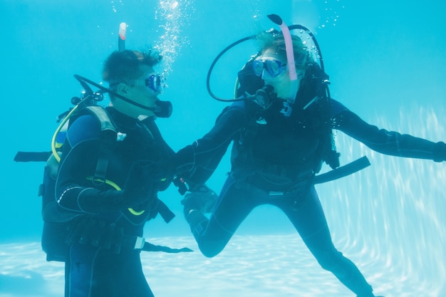 Des amis en plongée sous-marine dans une piscine