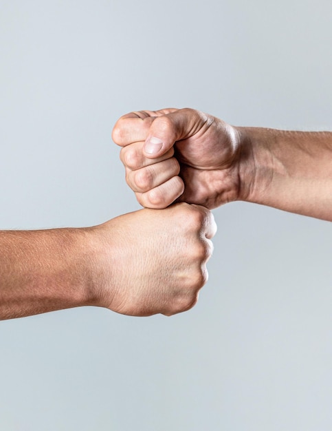 Photo amis de la poignée de main amicale salutation deux mains bras isolés homme donnant le coup de poing concept d'équipe les gens se cognant les poings ensemble les bras