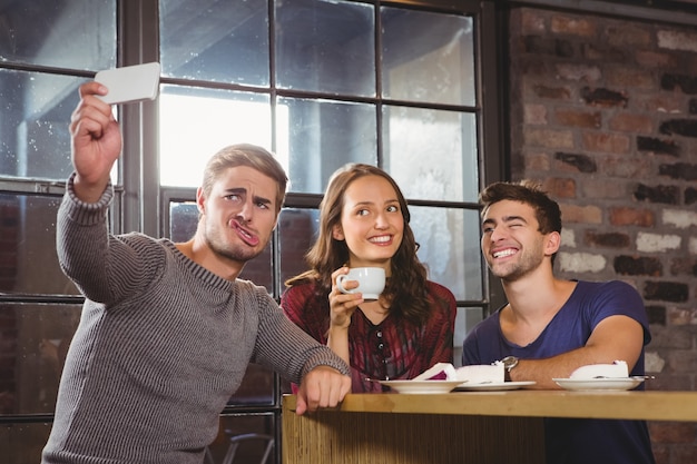 Amis prenant un café et prenant des selfies drôles