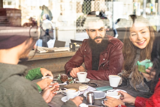 Photo des amis qui prennent du café à la table dans un café.