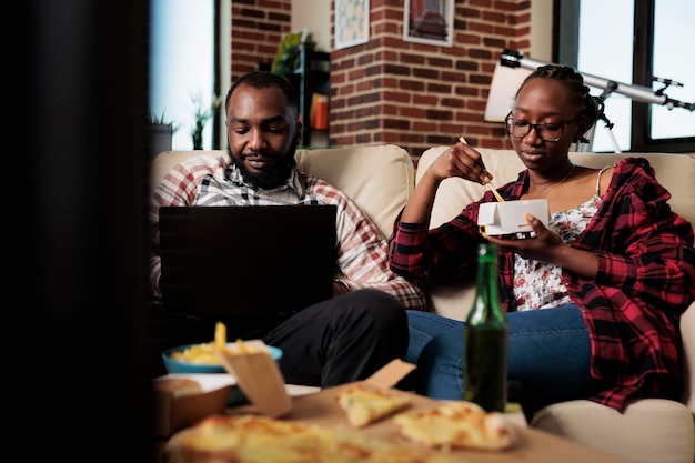 Photo des amis qui utilisent un ordinateur portable à la maison