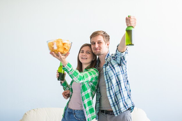 Des amis regardent le sport à la télévision ensemble, boivent de la bière