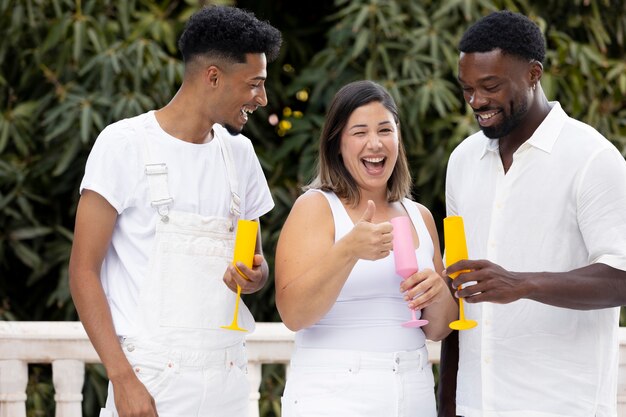 Photo amis s'amusant avec des boissons lors d'une soirée blanche