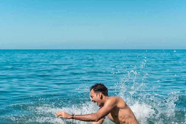 Amis s'amusant avec de l'eau dans la mer.