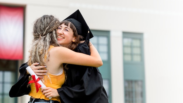 Amis s'embrassant lors de la cérémonie de remise des diplômes