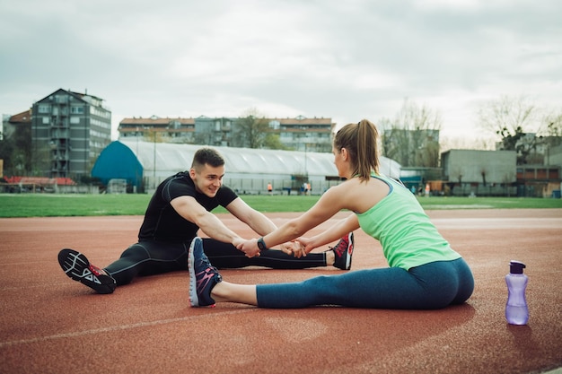 Des amis s'entraînent ensemble sur une piste de sport.