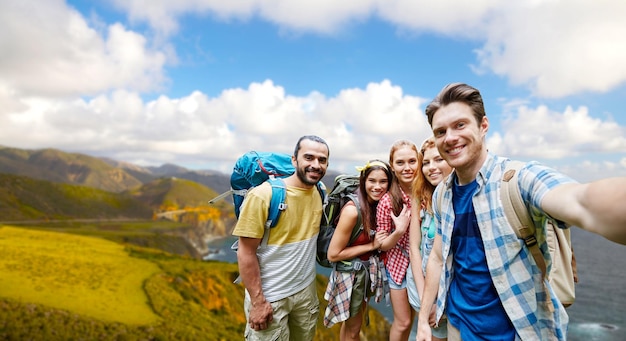 des amis avec des sacs à dos prenant des selfies