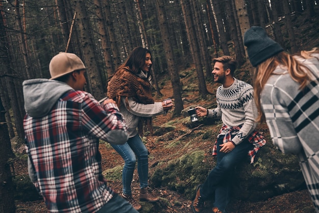 Amis solidaires. Groupe de jeunes heureux passant du temps ensemble lors d'une randonnée dans les bois