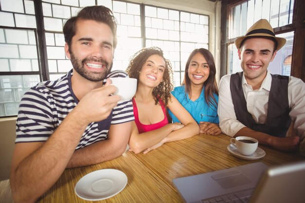 Amis souriants appréciant le café ensemble