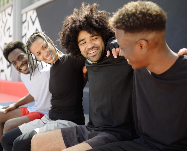 Photo des amis souriants assis à l'extérieur