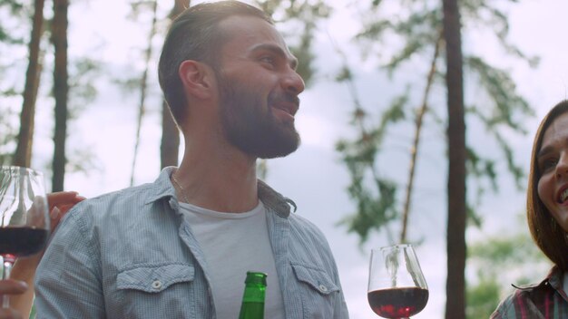 Amis souriants ayant une conversation à l'extérieur Homme parlant avec des amis à l'extérieur