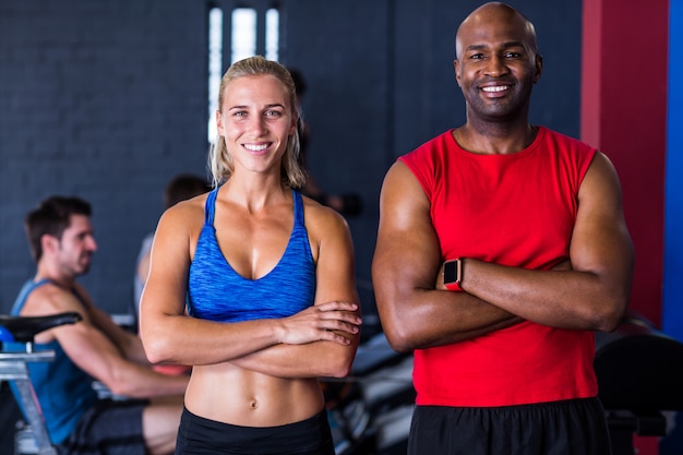 Photo amis souriants avec les bras croisés dans la salle de gym