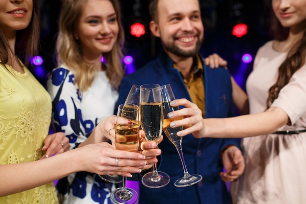 amis souriants avec coupes de champagne en club