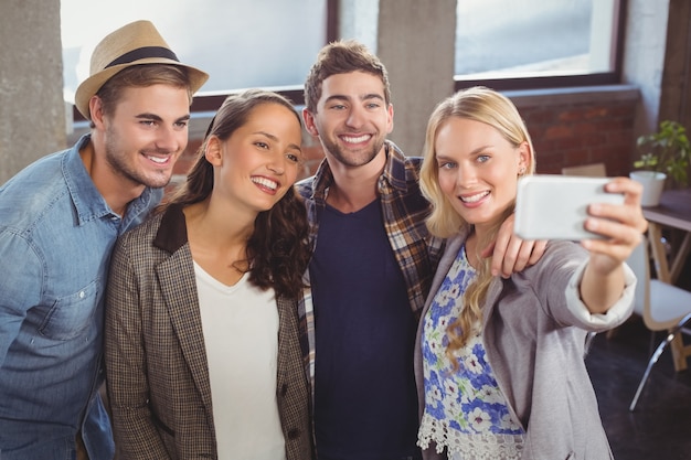 Amis souriants debout et prenant des selfies