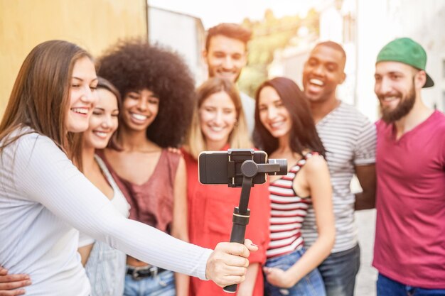 Photo des amis souriants prenant un selfie alors qu'ils sont dehors