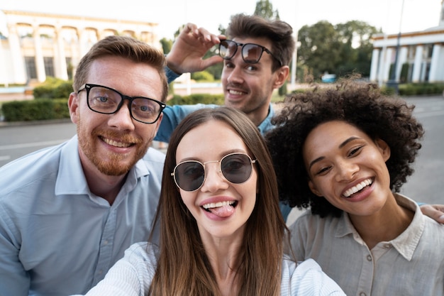 Photo amis souriants prenant un selfie ensemble à l'extérieur