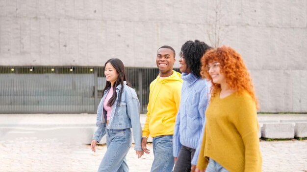 Des amis souriants en se promenant dans la rue.