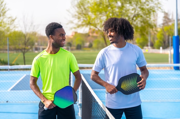 Des amis souriants sur un terrain de pickleball