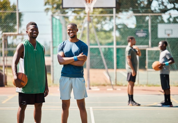 Amis sportifs et basket-ball par l'équipe de basket-ball sourire heureux et fier au terrain de basket Portrait d'hommes de fitness et de joueurs athlétiques excités pour le jeu d'entraînement et le match d'entraînement sur le terrain