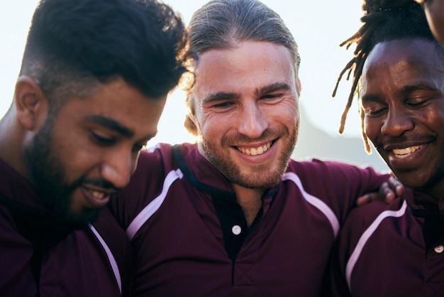 Photo amis, sports et travail d'équipe avec des gens et câlins pour un défi de santé et une compétition soutenir la communauté et un match de rugby avec un groupe d'hommes s'entraînant dans un stade pour une forme physique heureuse et des jeux ensemble