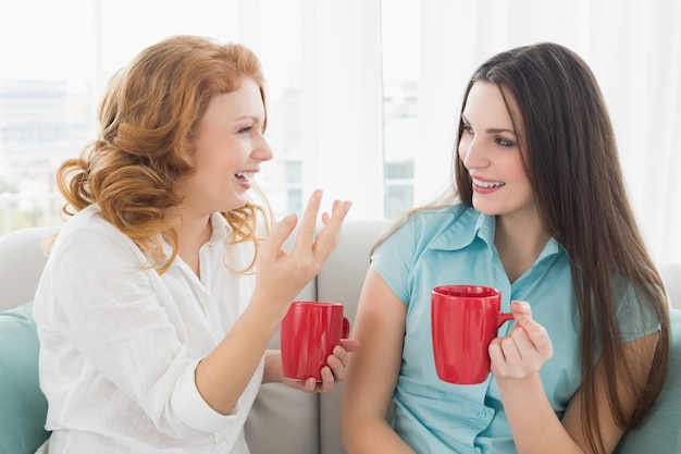 Amis avec des tasses de café converser à la maison