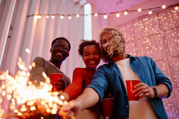 Amis tenant des lumières à la fête