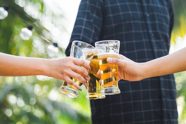 Amis tintant une bouteille de bière pendant le camping en plein air