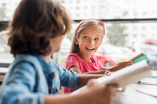 Photo amis travaillant ensemble pour leurs devoirs à la bibliothèque