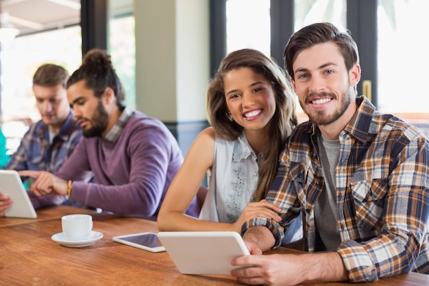 Amis utilisant des tablettes numériques dans les restaurants