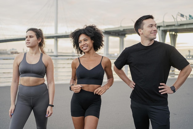 Des amis en vêtements de sport se tenant ensemble prévoient de commencer à s'entraîner