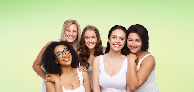 Amitié, beauté, corps positif et concept de personnes - groupe de différentes femmes heureuses en sous-vêtements blancs sur fond naturel vert