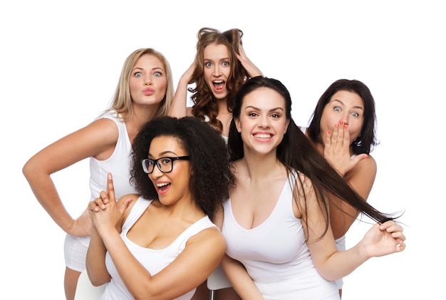 Amitié, beauté, corps positif et concept de personnes - groupe de femmes heureuses de taille plus en sous-vêtements blancs s'amusant et faisant des visages