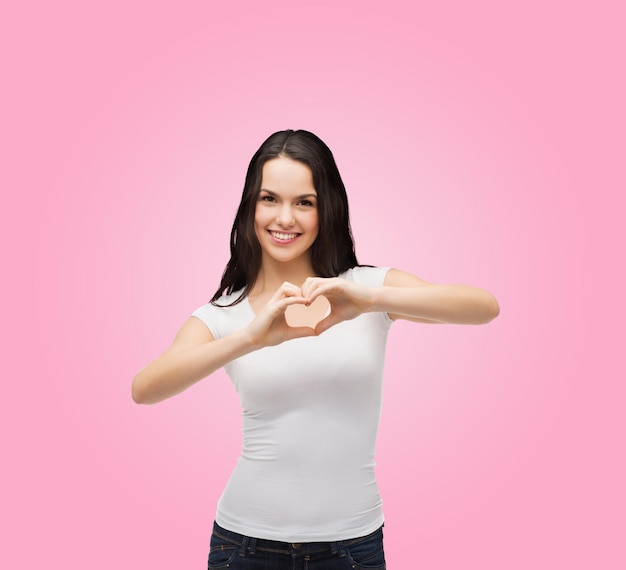 amitié, conception de t-shirts et concept de personnes heureuses - fille souriante en t-shirts blancs vierges montrant le coeur avec les mains