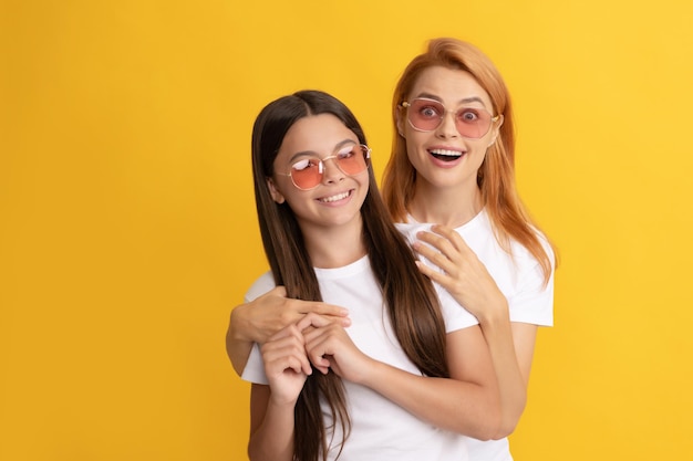 Amitié enfant et maman embrassant mère et fille à lunettes de soleil beauté et mode mannequin féminin jeunes filles à lunettes portrait d'enfant heureux et maman expriment des émotions positives