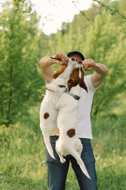 Amitié homme et chien. L'homme joue les chiens Jack Russell Terrier dans le pré.