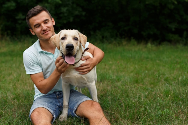 Amitié de l'homme et du chien. Heureux jeune homme joue avec son ami