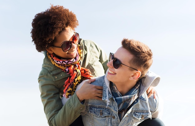 Amitié, loisirs, international, liberté et concept de personnes - heureux couple d'adolescents dans les tons s'amusant à l'extérieur