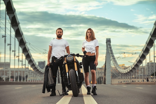 Amour et concept romantique beau couple sur moto se dresse face à face au milieu de la route sur le pont, sur double solide.