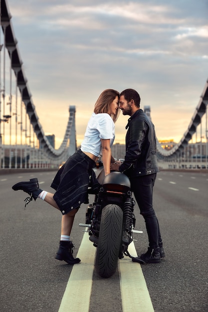 Photo amour et concept romantique. beau couple en moto se dresse face à face au milieu de la route