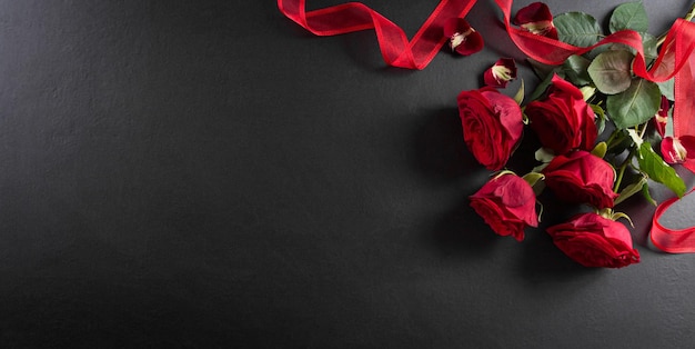 L'amour et le concept de la Saint-Valentin à base de rose rouge et boîte-cadeau sur fond de bois noir Vue de dessus avec copie espace mise à plat