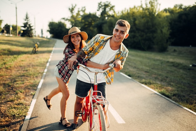 Amour couple amusant dans le parc d'été, vélo vintage