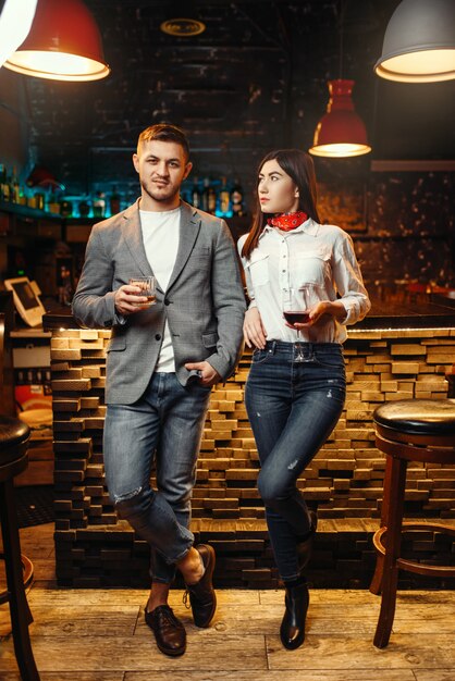 Amour couple debout contre le comptoir du bar