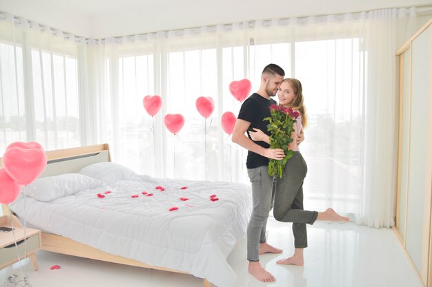 Amour Couple donnant une fleur rose dans le bonheur de la chambre dans le concept de la Saint-Valentin amoureuse