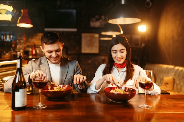 Amour couple flirtant au comptoir de bar en bois