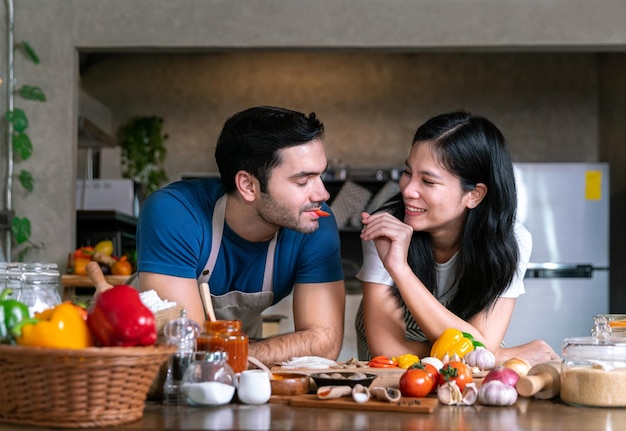 Amour couple marié petit ami et petite amie cuisinent ensemble dans la cuisine avec un plaisir heureux et un moment de romance amoureuse pour préparer un repas sain pour célébrer le jour de la Saint-Valentin