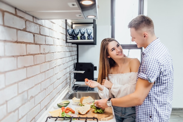 Amour couple prépare un dîner romantique dans la cuisine avec des produits